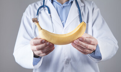 Caucasian doctor showing banana.