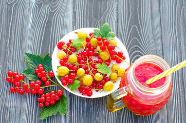 Fresh berry smoothie with red currant and yellow gooseberry on a wooden rustic table. Healthy eating, Summer food, Detox or Diet concept. Copy spase, top veiw.