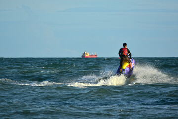A man riding a water scooter Summer vacation in the tropical sea The hobby of a young man riding the sea Water sport scooter activities	