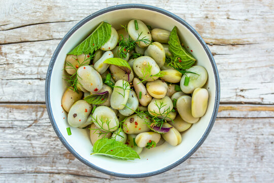 A healthy rich protein salad made from broad beans and fresh herbs. Vegetarian food.