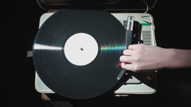 Video of girl with red nails turning off old gramophone