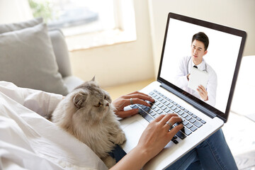 young asian woman talking to doctor via video call using laptop computer