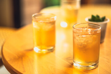 Clear wellness yellow drink lemonade, fruit tea, ice kombucha, green tea in two glasses on wooden...