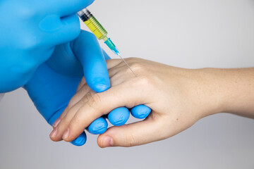 Orthopedic surgeon gives an injection in the finger joint. Treatment of osteoarthritis with...