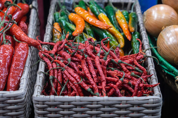Basket with red and green chilli pepper in the shop .