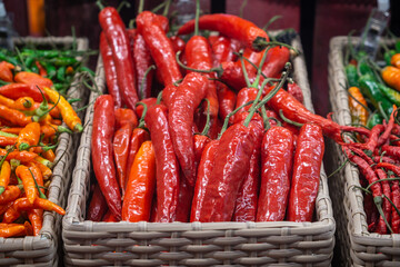 Basket with red and green chilli pepper in the shop .