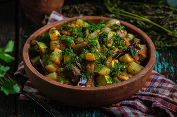 Vegetable roast eggplant and potatoes in a clay plate (ketsa). Homemade healthy food in a rustic style.