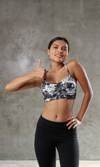 Obraz premium Beautiful young Asian woman at the gym. Happy girl spending her free time at the sport centre