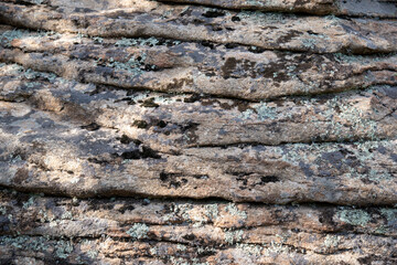 Close-up texture of layered stone with moss