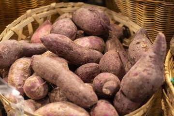 Basket with red sweet potatoes in shop .
