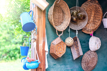 Second-hand blue saucepans, small bucket , jug and old straw baskets turn into garden flower pots. Recycled garden design and low-waste lifestyle. Reduce, reuse, recycle planter craft ideas.