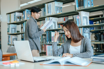 Students studying in the library with laptop at the university. Education concept.