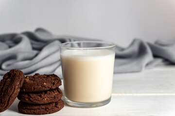 stuck of chocolate brownie cookies and glass of coconut milk on wooden background. Homemade pastry