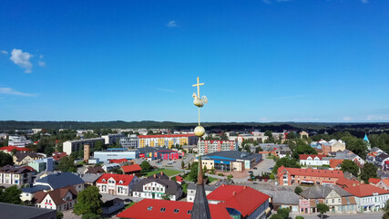 Aerial View of the  Holy Trinity Lutheran Church in Tukums, Latvia. Golden Cock Statue on the Top of Tower. Tukums City Park on the  the Background. Sunny Summer Day.