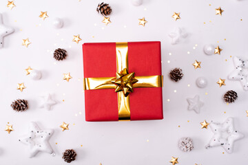 Red Christmas gift box with its lid propped at an angle in front to display the beautiful shiny metallic gold ribbon