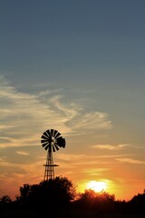 windmill at sunset in Kansas with clouds.