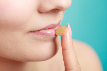 woman applying balsam for lips - obrazy, fototapety, plakaty