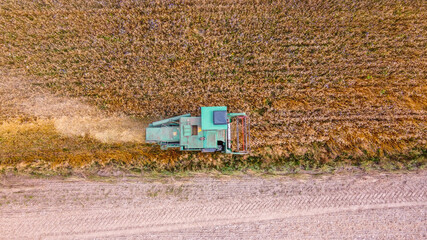 Fototapeta na wymiar Green harvester in top view while harvesting crops at an agricultural field with copy space