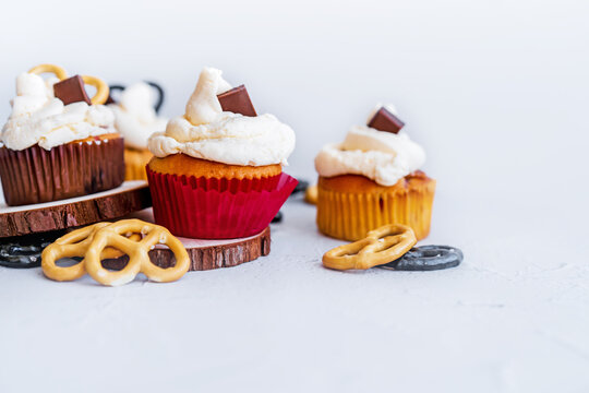 Festive delicious cupcakes with chocolate, strawberries and pretzels painted on a white background