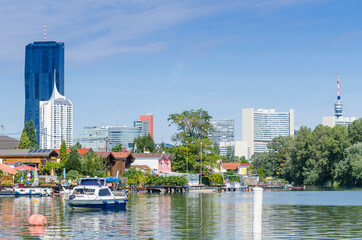 Summer houses on the banks of the Alte Donau. UNO City skyscrapers in the background.