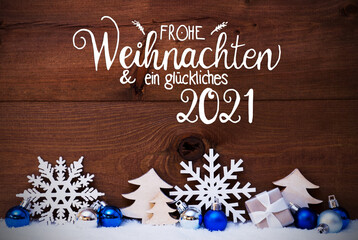 Fototapeta na wymiar German Calligraphy Frohe Weihnachten Und Ein Glueckliches 2021 Means Merry Christmas And Happy 2021. Blue Christmas Decoration Like Tree, Gift And Ball. Wooden Background With Snow