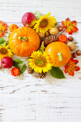 Happy Thanksgiving concept. Pumpkins, sunflowers, apples and fallen leaves on rustic wooden table. Top view flat lay. Copy space.