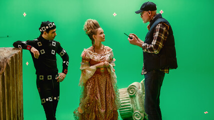 On Period Costume Drama Film Set: Beautiful Smiling Actress Wearing Renaissance Dress and Actor Wearing Motion Capture Suit Listen to Movie Director Explaining to Her Scene Context.