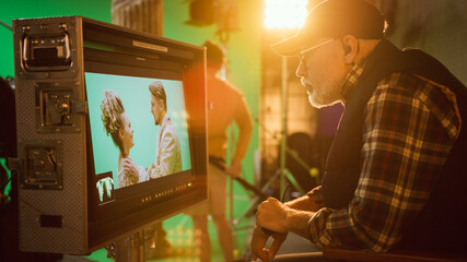 Director Looks at Display Controls Shooting Period Drama Movie. Green Screen CGI Scene with Actors...