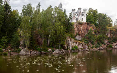 Autumn Monrepos Park with small vintage castle on granite rock near big lake