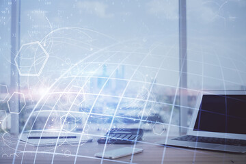 Double exposure of desktop with computer and world map hologram. International data network concept.