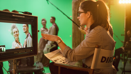 Famous Talented Female Director in Chair Looks at Display Following Shootings of a New Blockbuster. Green Screen Scene in Historical Drama. Film Studio Set Professional Crew Doing High Budget Movie