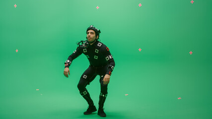 Fototapeta premium Actor Wearing Motion Caption Suit and Head Rig acts as an Animal or a Monster for CGI Green Screen Scene. Big Budget Filmmaking On Film Studio Set Shooting Blockbuster Movie with Chroma Key