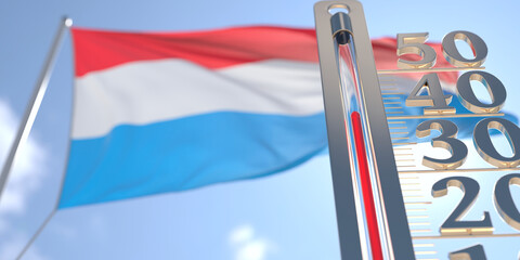Thermometer shows high air temperature against blurred flag of Luxembourg. Hot weather forecast related 3D rendering