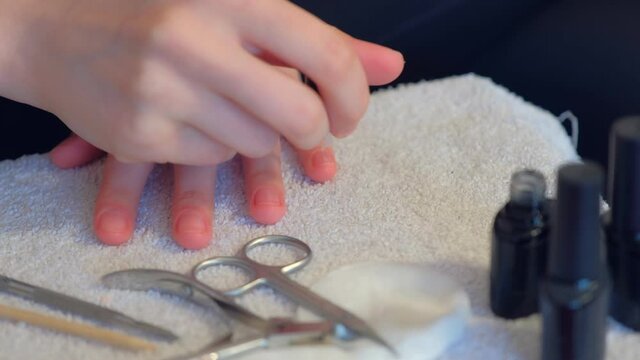 Woman is applying primer using brush on nails before cover it shellac gel polish, hands closeup. Girl making manicure at home for herself. Hygiene care about nails. Beauty procedure.