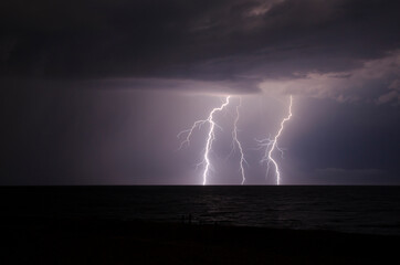 Naklejka na ściany i meble Flash of lighting during a summer storm in the Black Sea