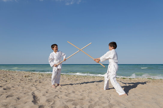 Kids practicing Aikido on the beach. Healthy lifestyle and sports concept