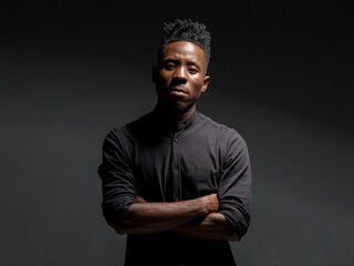 emotional portrait of a young African man in a black shirt against a black background