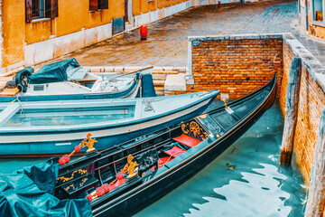 Fototapeta na wymiar Views of the most beautiful channels of Venice, empty gondola near the Pier. Venice, Italy.