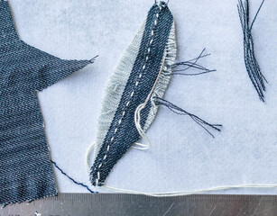 Making of bird feather from old jeans. Step 3. Decorate  the feather stich with embroidery and make a barb. 