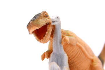 Baby toys smiling dinosaurs close up on white background.