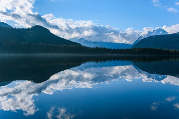 Fototapeta na wymiar Beautiful blue lake with surrounding mountains reflecting back