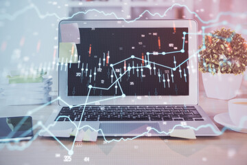 Financial chart drawing and table with computer on background. Double exposure. Concept of international markets.