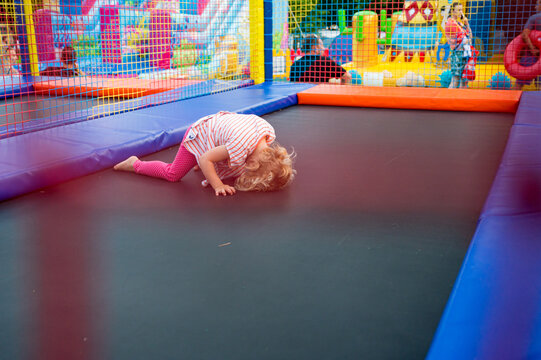 Cute blonde girl having fun at outdoor trampolin.