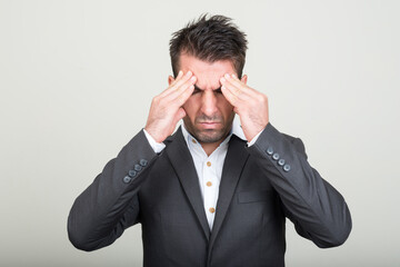 Portrait of young handsome Hispanic businessman in suit