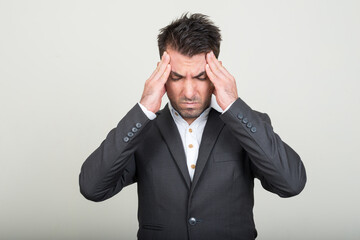 Portrait of young handsome Hispanic businessman in suit