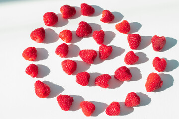 
Raspberries on a white plate and with mint in the middle.