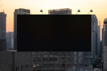 Blank black road billboard with Bangkok cityscape background at sunset. Street advertising poster, mock up, 3D rendering. Front view. The concept of marketing communication to promote or sell idea. © VideoFlow