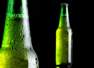 Still life di una bottiglia di birra ghiacciata su sfondo nero 