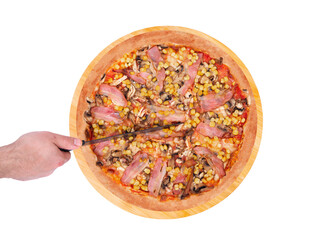 Cook cuts the pizza with a kitchen knife. Delicious pizza with chicken breast, corn, bacon and mushrooms on a round wooden plate, isolated on white background, top view