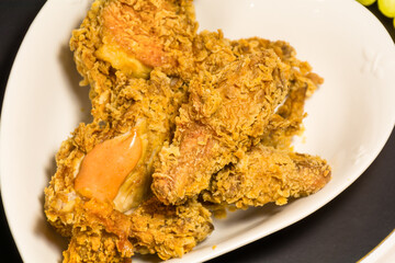 hot and spicy chicken broasted in white plates and fries with ketchup